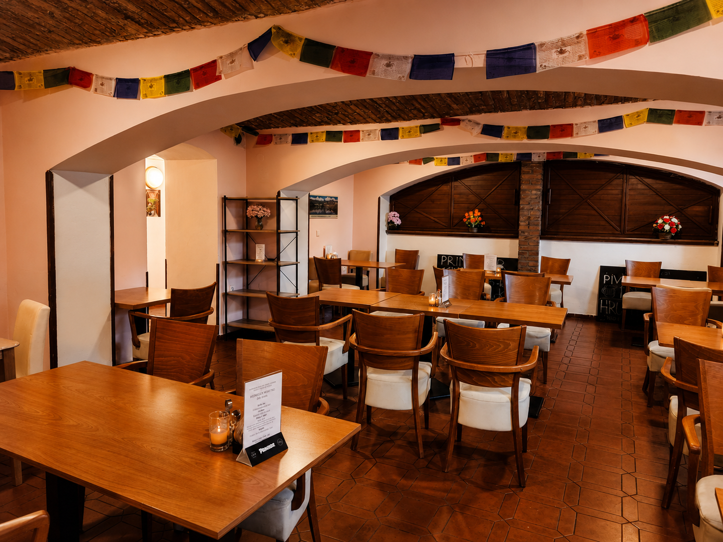 Další část interiéru restaurace Sargam s dřevěnými stoly